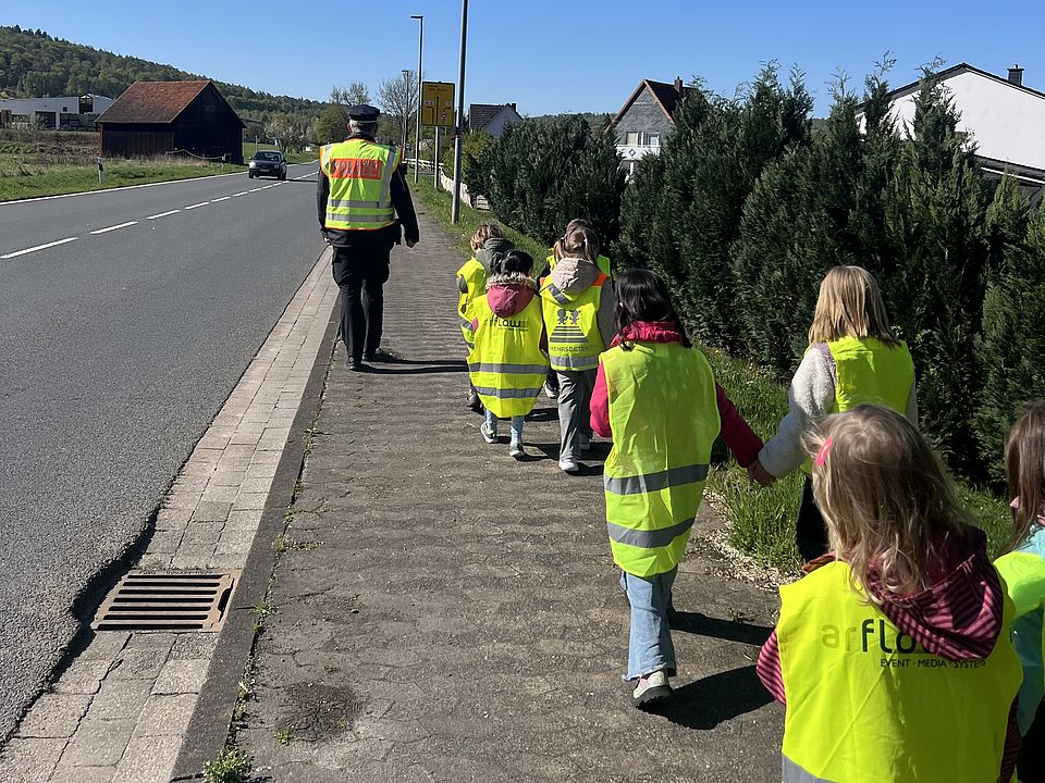 2026_04_27_Vorschularbeit_Kita_Volkmarshausen__1_.jpeg Kinder der DRK-Kita Volkmarshausen in gelben Warnwesten laufen die Straße entlang im Rahmen ihrer Fußverkehrsprüfung