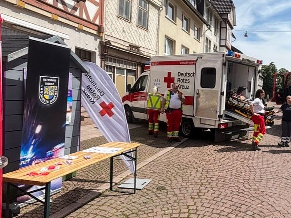 DRK-Infostand neben Rettungswagen beim Bienenmarkt Uslar in der Altstadt
