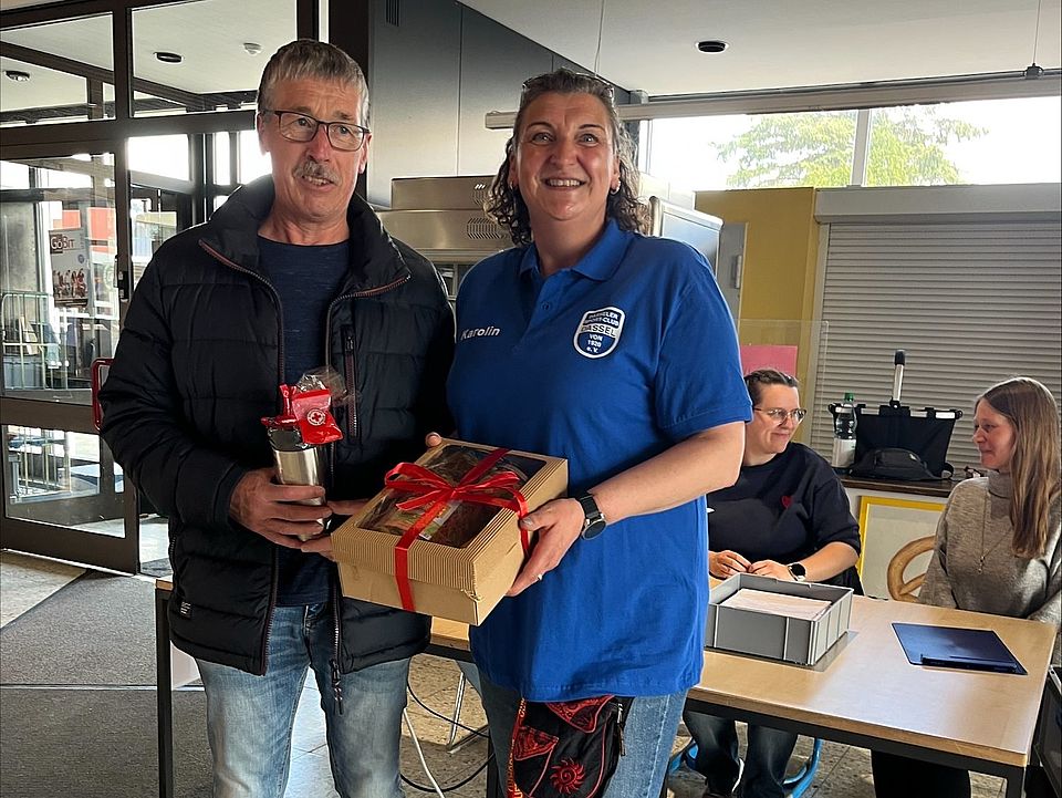 Blutspende des DRK in Dassel, Spender erhält ein Geschenk, gemeinsames Foto mit einer Ehrenamtlichen