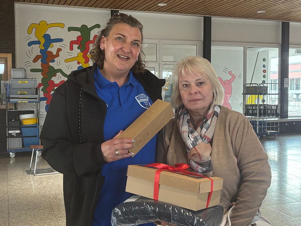 Blutspende des DRK in Dassel, Spenderin erhält ein Geschenk, gemeinsames Foto mit einer Ehrenamtlichen