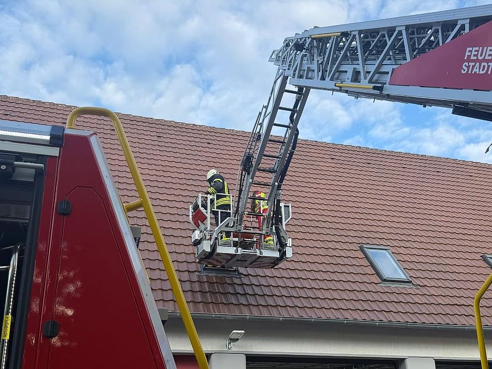 2026_06_03_Rettungsdienstübung_Uslar_mit_Feuerwehr_-_Rettung_in_Höhe_und_Tiefe__14_.jpeg DRK-Kreisverband Göttingen-Northeim e. V., Rettungsdienst und Feuerwehr bei Übung „Rettung in Höhe und Tiefe“ in Uslar: Drehleiterkorb auf Höhe eines Hausdachs mit Einsatzkräften im Korb