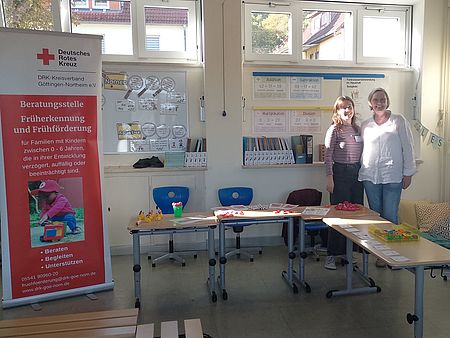 Stand der Frühförderung mit zwei Mitarbeitenden und Informationsmaterialien und Roll-Up