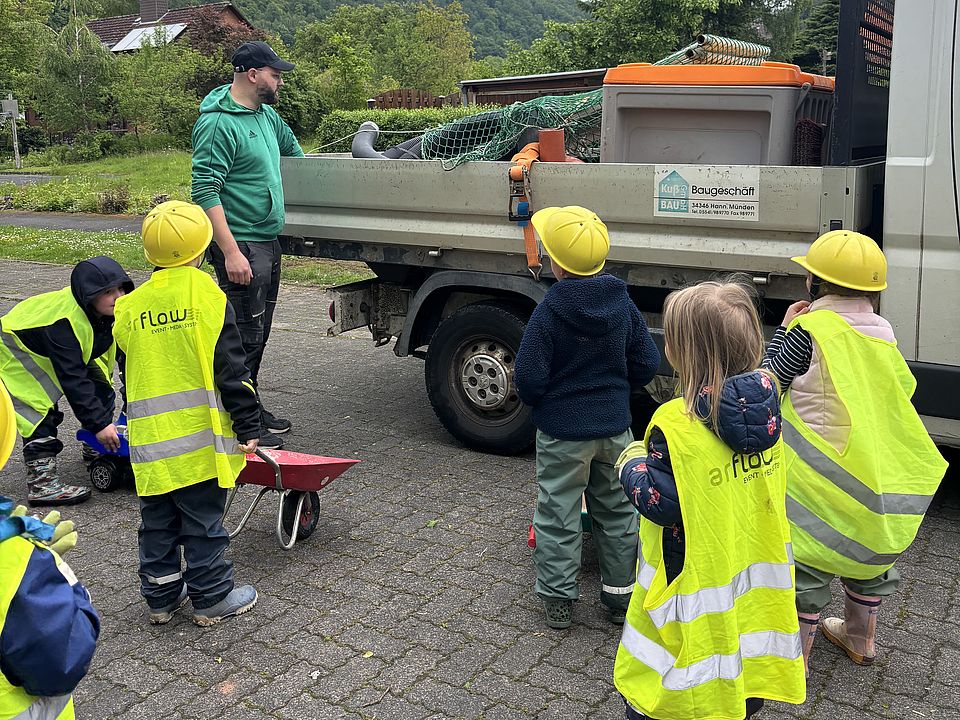 2026_05_27_Baustellentag_für_die_Kinder__2_.jpeg Kinder in Warnwesten und Bauhelmen erkunden beim Baustellentag der DRK‑Kita Volkmarshausen einen Baustellen‑Transporter