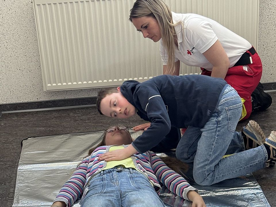 Zukunftstag beim DRK-Kreisverband Göttingen-Northeim e. V.: Kinder und Jugendliche verschiedener Göttinger Schulen zu Besuch. Rettungssanitäterin Ricarda Jung zeigt zwei Schülerinnen Erste-Hilfe Maßnahmen