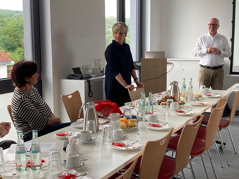 Jahreshauptversammlung des DRK-Ortsverein Göttingen, an den Tischen Mitglieder und Essen und Getränke, die neue 1. Vorsitzende Frau Golda steht am Tisch, Frank Wiegelmann und Kreisgeschäftsführerin Petra Reußner lächeln sie an