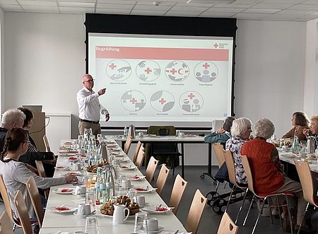 Bisheriger Vorsitzender Frank Wiegelmann hält eine Präsentation auf der Jahreshauptversammlung des DRK-Ortsverein Göttingen, an den Tischen Mitglieder