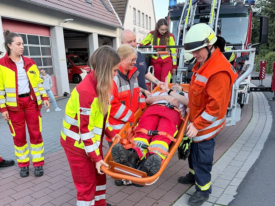 2026_06_03_Rettungsdienstübung_Uslar_mit_Feuerwehr_-_Rettung_in_Höhe_und_Tiefe__7_.jpeg Übung „Rettung in Höhe und Tiefe“ in Uslar: DRK-Kreisverband Göttingen-Northeim e. V. und Feuerwehr transportieren Person auf Schleifkorbtrage vor Feuerwehrhaus