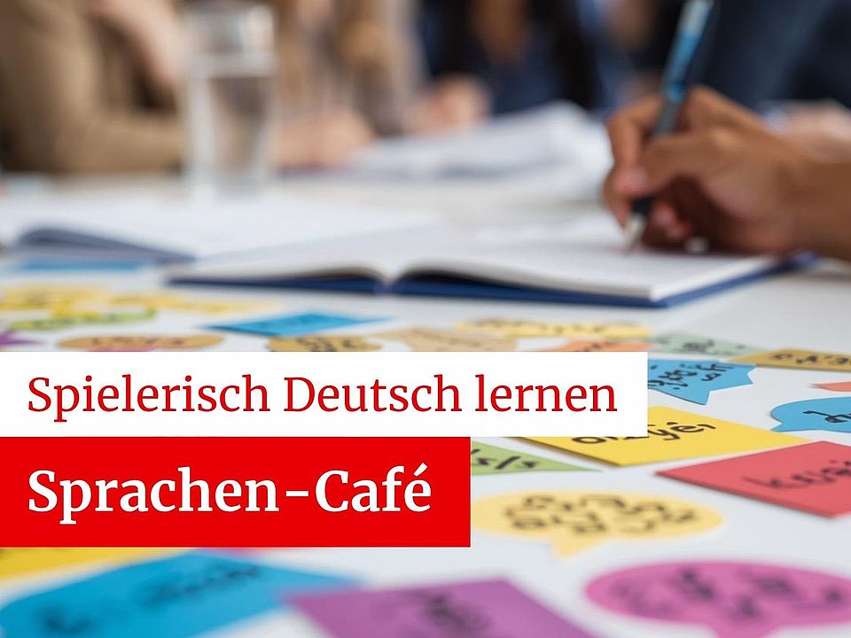 Menschen an einem Tisch im Hintergrund sichtbar, mit vielen bunten Karten zum Sprachenlernen auf dem Tisch, eine Person schreibt etwas. Bewerbung des Sprachen-Cafes des DRK-OV Göttingen "Spielerisch Deutsch lernen"