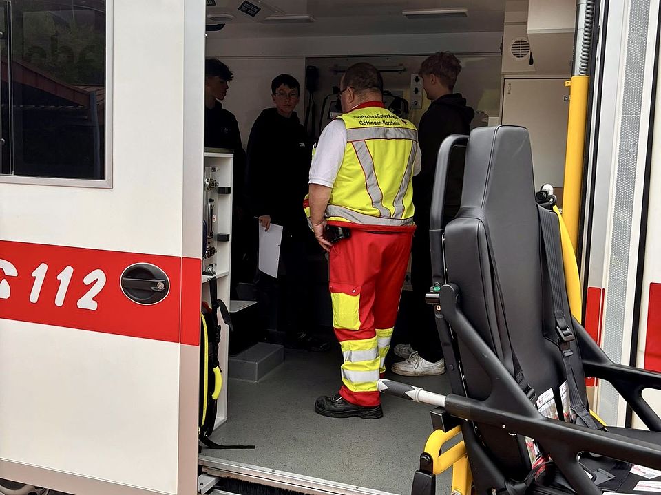 Berufetag an der IGS Bovenden, Rettungswagen und eine Gruppe Schüler*innen am Stand des DRK-Kreisverbandes Göttingen-Northeim e. V