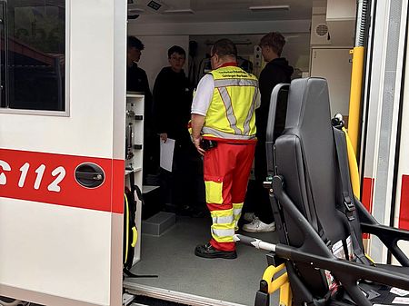 Berufetag an der IGS Bovenden, Rettungswagen und eine Gruppe Schüler*innen am Stand des DRK-Kreisverbandes Göttingen-Northeim e. V