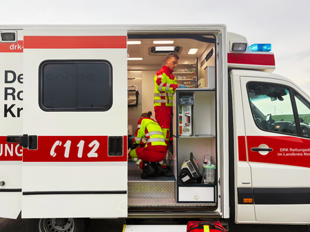 Rettungswagen des DRK-Kreisverbandes Göttingen-Northeim e. V. mit offener Tür und Rettungskräften