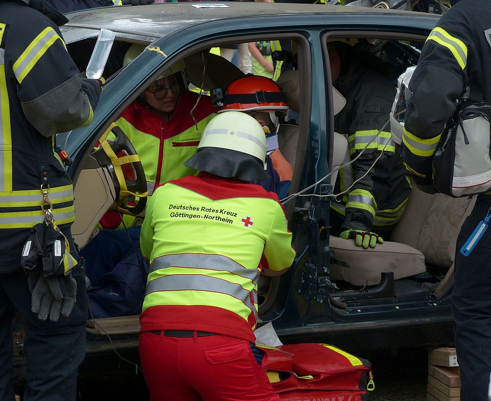 2023_09_05_25_J_RD_Duderstadt Rettungsdienstmitarbeitende des DRK Rettungsdienst in Südniedersachsen gGgmbH bei einer Übung. Mehrere Mitarbeitende in Uniform versuchen eine Person aus dem Auto zu befreien
