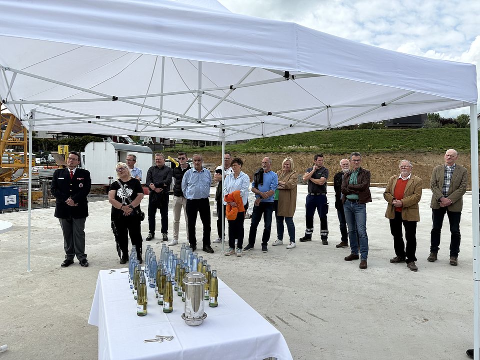 Rede von Torsten Bauer und Petra Reußner bei der Grundsteinlegung der neuen DRK-kita in Uslar. Pavillion mit zuschauenden Gästen und Zeitkapsel