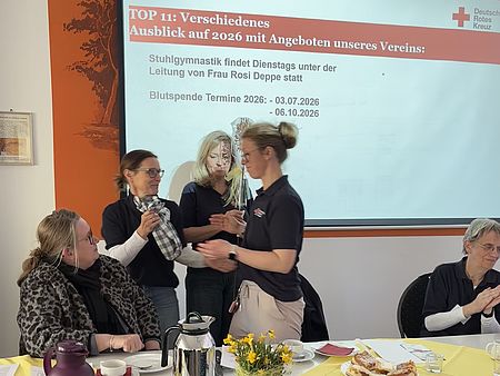 Ehrung während der Jahreshauptversammlung des DRK-Ortsvereins Katlenburg im Dorfgemeinschaftshaus mit Präsentationsfolie im Hintergrund.