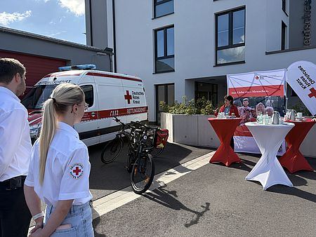 Vor dem DRK-Standort in der Zimmermannstraße 4 verfolgen Teilnehmende die Ansprache zur Gründung der ersten Fahrradstaffel des DRK-Kreisverbands Göttingen-Northeim. Im Vordergrund stehen die neuen E-Bikes der Staffel