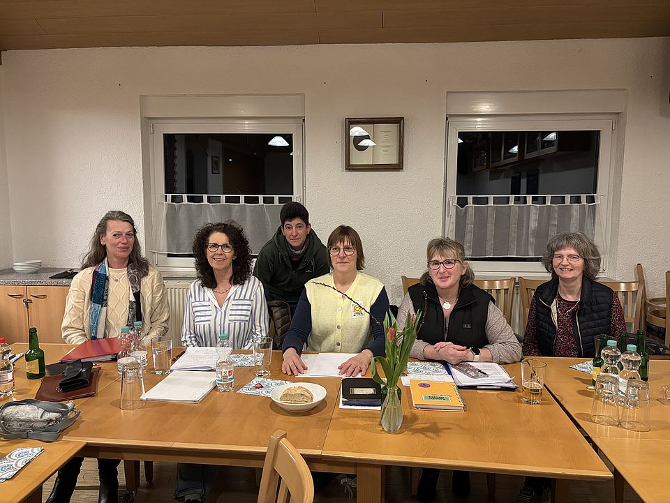 Sechs Anwesende auf der Jahreshauptversammlung des DRK-Ortsvereins Immensen sitzen an einem Tisch und lächeln in die Kamera