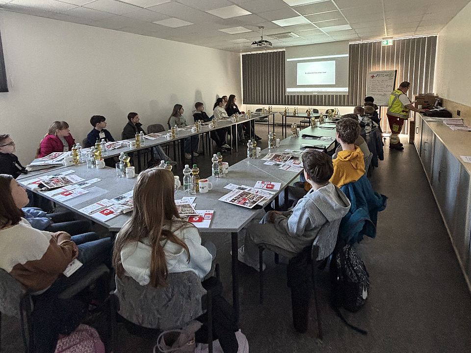 Zukunftstag beim DRK-Kreisverband Göttingen-Northeim e. V.: Kinder und Jugendliche verschiedener Göttinger Schulen zu Besuch. Die Gruppe an einem Tisch im Konferenzraum bei der Begrüßung