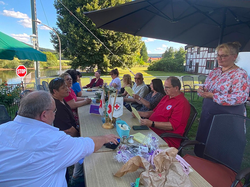2026_08_01_Sommerfest_HNR__3_.jpg Mitarbeitende des DRK-Hausnotruf im DRK-Kreisverband Göttingen-Northeim e. V. beim Sommerfest am Tisch beim Essen