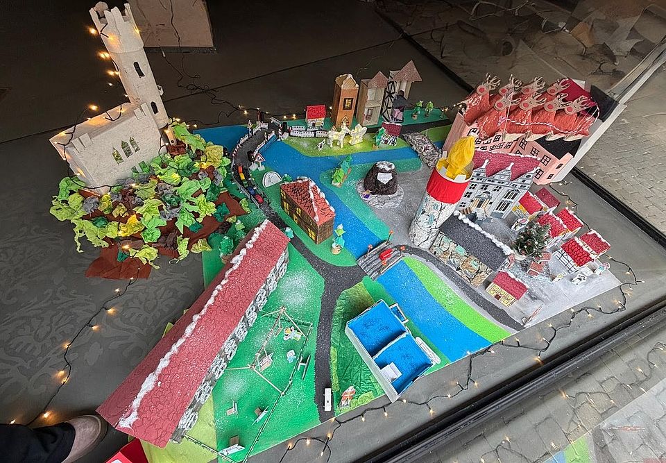 Aus Pappe dargestellt ein Teil der Stadt Hann. Münden mit Fluß und Brücke. Verschiedene Gebäude, farblich dekoriert, plus Weserstein und mit Lichterkette dekoriert.