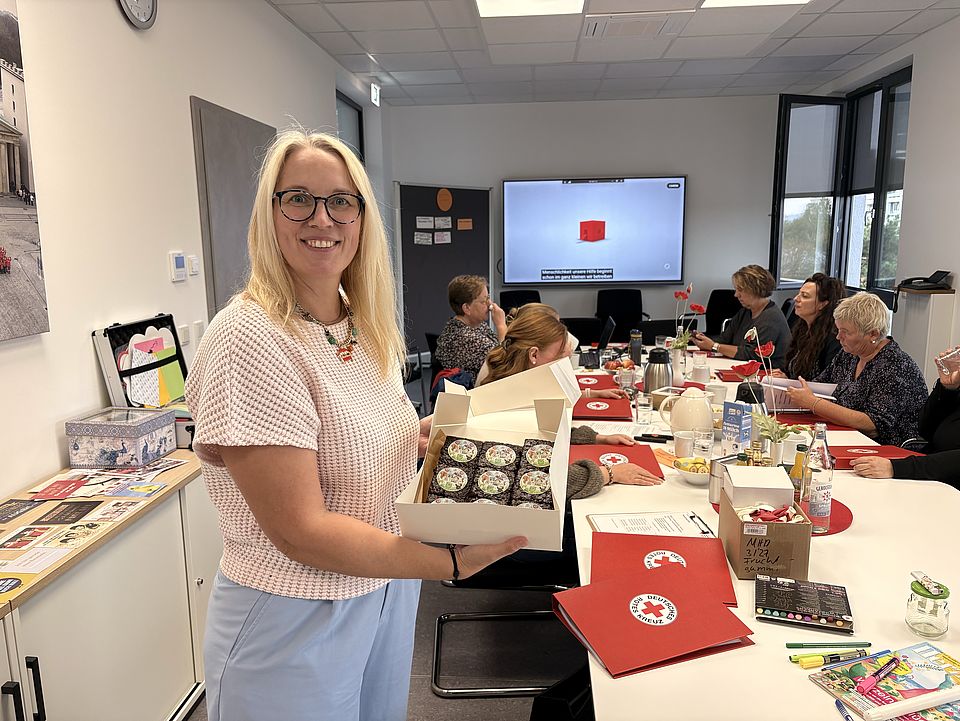 2026_10_01_Teamtag_Kita_Löwenhagen__5_.jpg Jennifer Treichel präsentiert beim Teamtag zum Trägerwechsel selbst gestaltete Brownies mit DRK-Motiv für das gemeinsame Kennenlernen.
