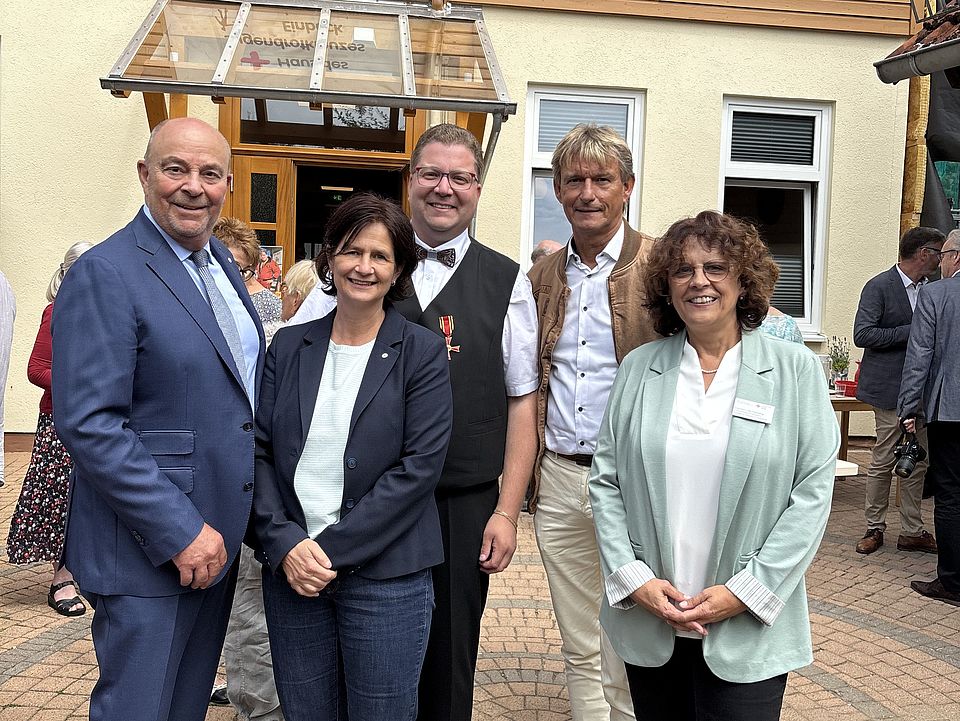 2026_07_04_Bundesverdienstkreuz_Jan_Störmer__5_.jpeg Gruppenfoto mit Präsident Dr. Hufenbach, Vorstandsvorsitzende im DRK-Kreisverband Göttingen-Northeim, Petra Reußner, Jan Störmer nach Verleihung des Bundesverdienstkreuzes beim DRK-Kreisverband Göttingen-Northeim e. V. vor dem Haus des Jugendrotkreuzes Einbeck