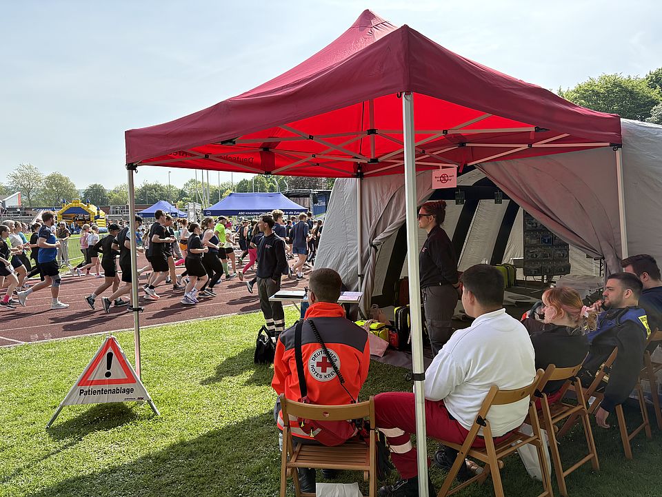 2026_5_10_Göttinger_Halbmarathon__6_.jpg Einsatz der DRK-Bereitschaft im Sanitätsdienst beim Göttinger Halbmarathon: Bereitschaftsmitglieder unter einem Pavillion der Unfallversorgungsstation, im Hintergrund Läufer*innen