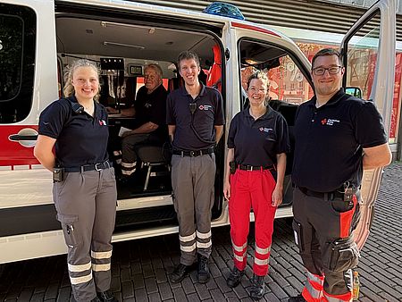 Ehrenamtliche Einsatzkräfte des DRK-Kreisverbandes Göttingen-Northeim e. V. vor Rettungsfahrzeug beim Sanitätsdienst Altstadtlauf Göttingen 2026