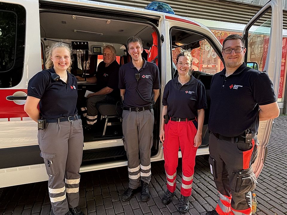 Ehrenamtliche Einsatzkräfte des DRK-Kreisverbandes Göttingen-Northeim e. V. vor Rettungsfahrzeug beim Sanitätsdienst Altstadtlauf Göttingen 2026