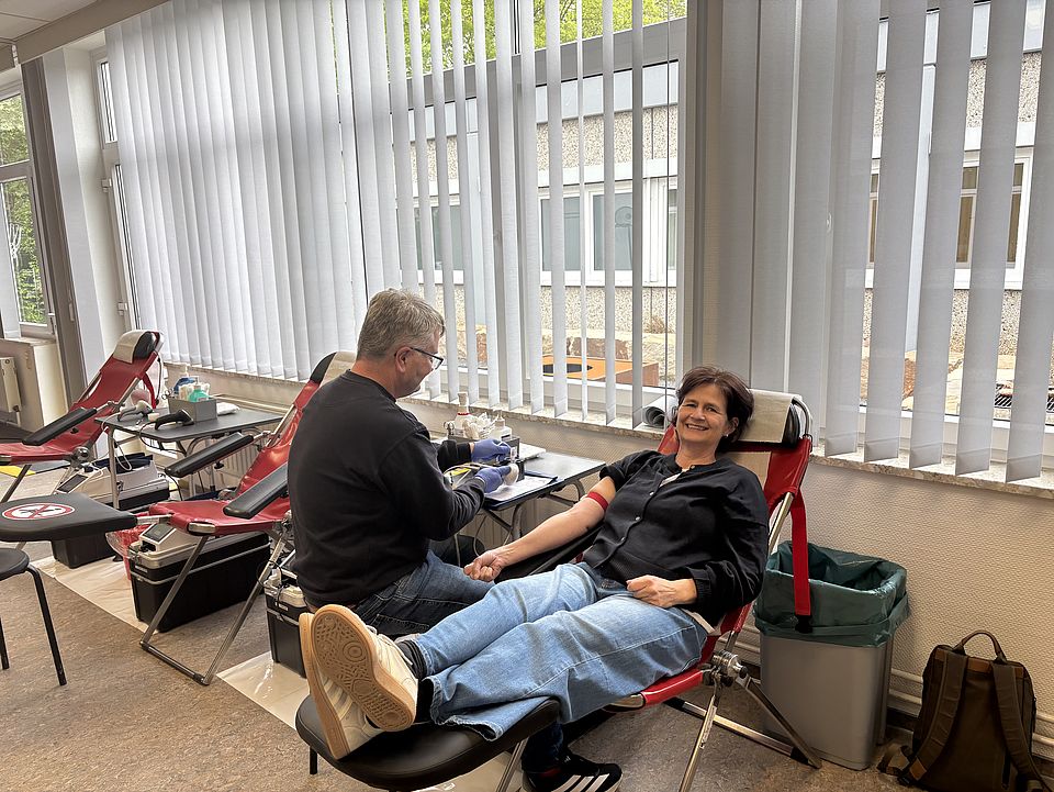 Blutspendeaktion beim DRK-Kreisverband Göttingen-Northeim e. V., Geschäftsführerin Petra Reußner bei der Blutspende auf einer Liege, daneben ein Mitarbeiter des DRK-Blutspendedienstes