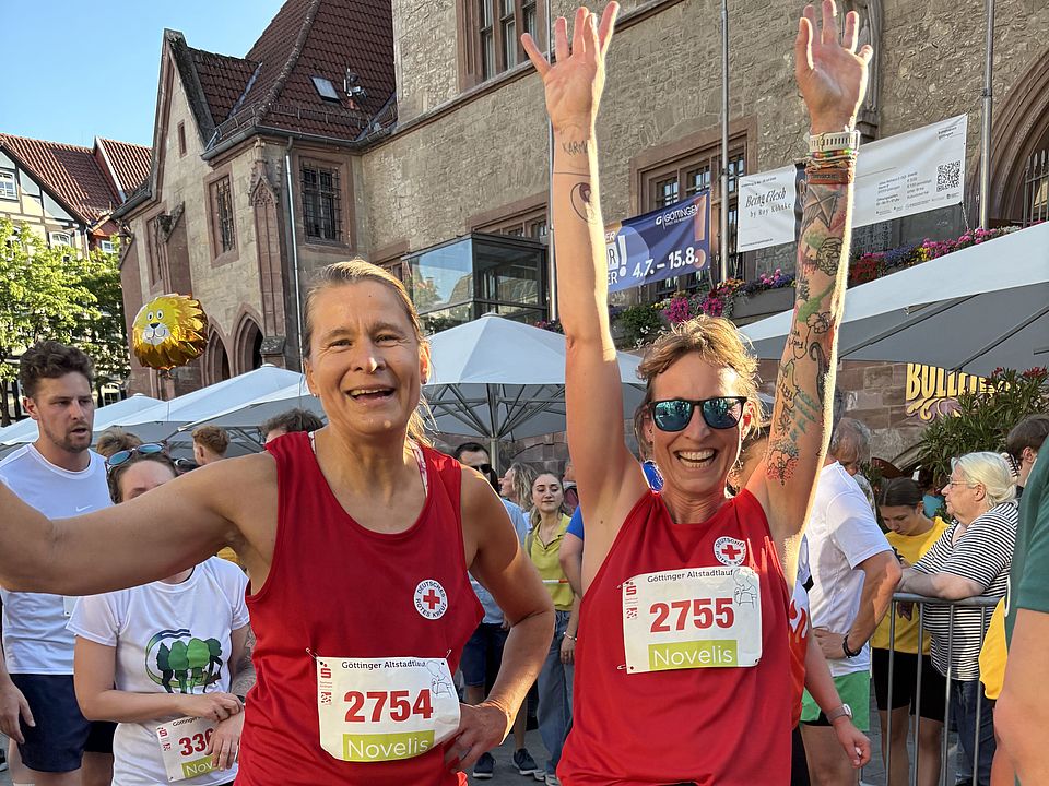 2026_07_01_Altstadt-Läuferinnen_01.jpeg DRK‑Läufer*innen beim Altstadtlauf Göttingen 2026 auf der Strecke mit erhobenen Armen im Ziel