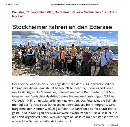 Seniorengruppe stehen in einer Gruppe vor der Staumauer, im Hintergrund der Edersee
