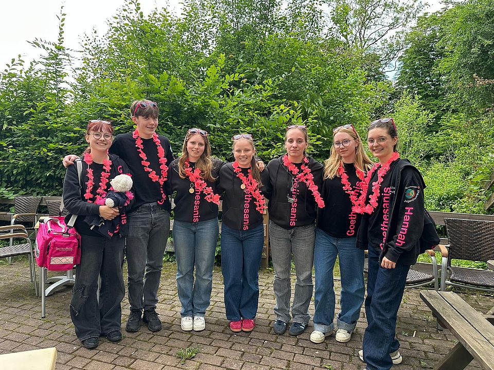 2026_06_06_Bezirkswettbewerb_JRK_Goethesanis_Qualifikation_f_Landeswettbewerb.jpeg Jugendrotkreuz-Mitglieder aus Einbeck bei der Siegerehrung, Gruppenfoto mit pinken Girlanden um den Hals