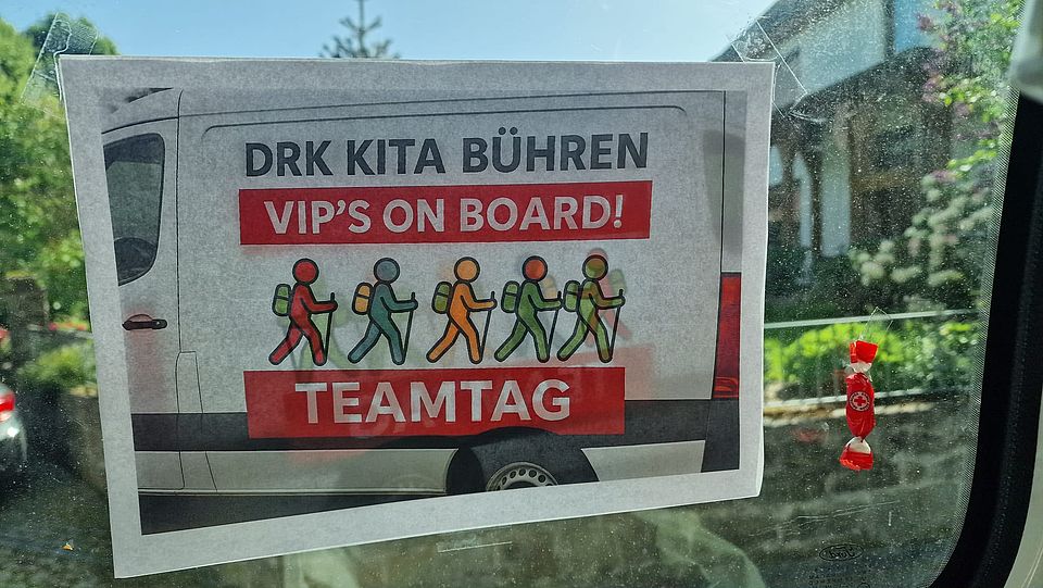2026_05_26_Teamtag_Kita_Bühren__12_.jpeg Schild „DRK Kita Bühren – VIP’s on Board! Teamtag“ im Fenster eines DRK-Fahrzeugs des DRK-Kreisverbandes Göttingen-Northeim e. V.