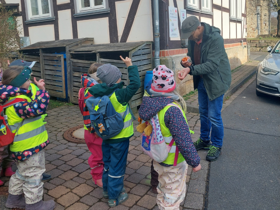 Ein Mitglied des Förderverein Bührener Schedetal Natur & Artenschutz e.V. mit Kindern der DRK-Kita Bühren in gelben DRK-Westen