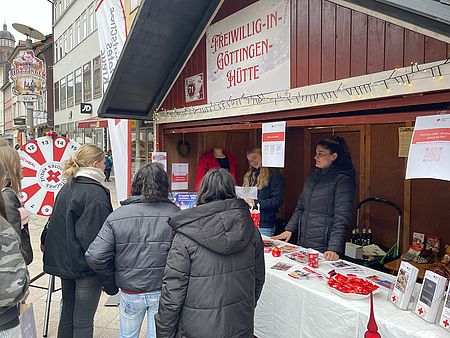 Die Freiwillig-in-Göttingen-Hütte mit zwei DRK Ehrenamtlichen und drei Interessierten, die sich am Stand informieren