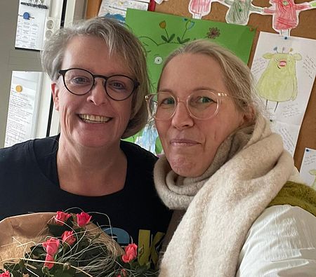 Frau Greil und Frau Treichel aus der Kita Fachberatung mit einem Blumenstrauß als Dankeschön für 30 Jahre Mitarbeit