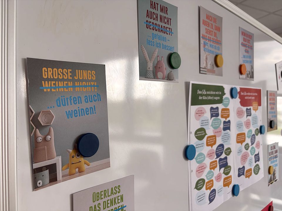 2026_07_07_Workshop_Sprache_und_Adultismus_für_pädagogische_Fachkräfte__29_.jpeg An einer Wand hängen mehrere Plakate mit Sätzen zur Reflexion von Sprache gegenüber Kindern, zum Beispiel „Große Jungs weinen nicht … dürfen auch weinen!“. Ergänzt werden sie durch Übersichten mit Formulierungsalternativen für den Kita-Alltag im Workshop des DRK-Kreisverbands Göttingen‑Northeim e. V.