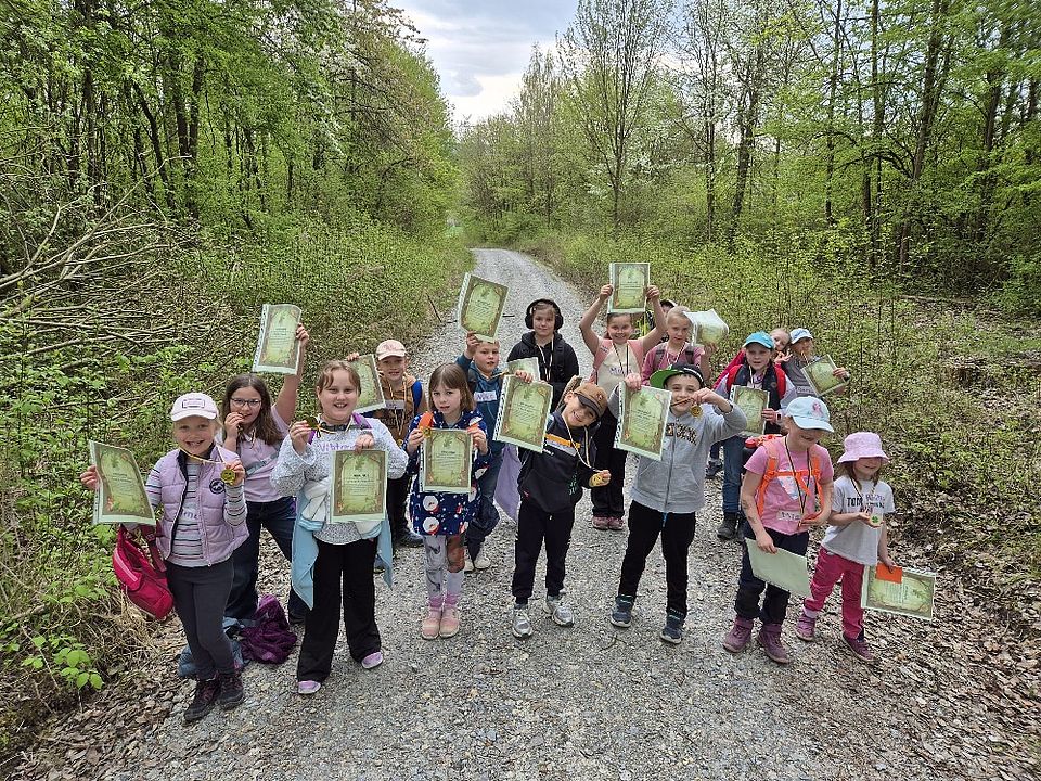 Kinder beim Walderlebnistag des DRK-Ortsvereins Harste in einer Gruppe im Wald, in der Hand halten sie Urkunden