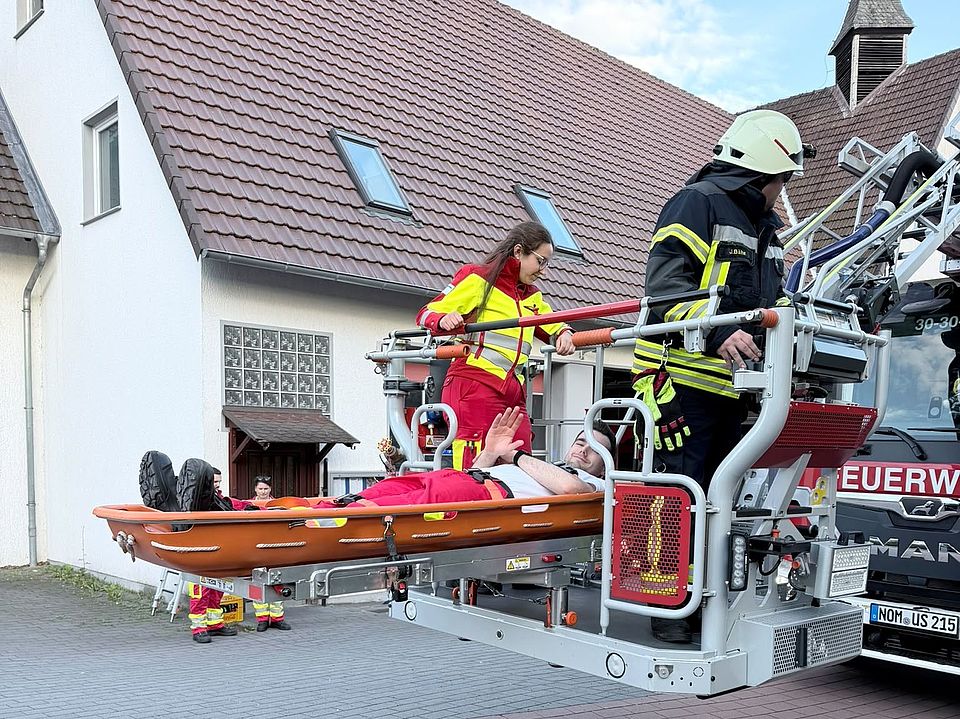 2026_06_03_Rettungsdienstübung_Uslar_mit_Feuerwehr_-_Rettung_in_Höhe_und_Tiefe__21_.jpeg DRK-Kreisverband Göttingen-Northeim e. V., Rettungsdienst, DRK-Bereitschaft und Feuerwehr bei Übung „Rettung in Höhe und Tiefe“ in Uslar: Patient auf Schleifkorbtrage im Drehleiterkorb